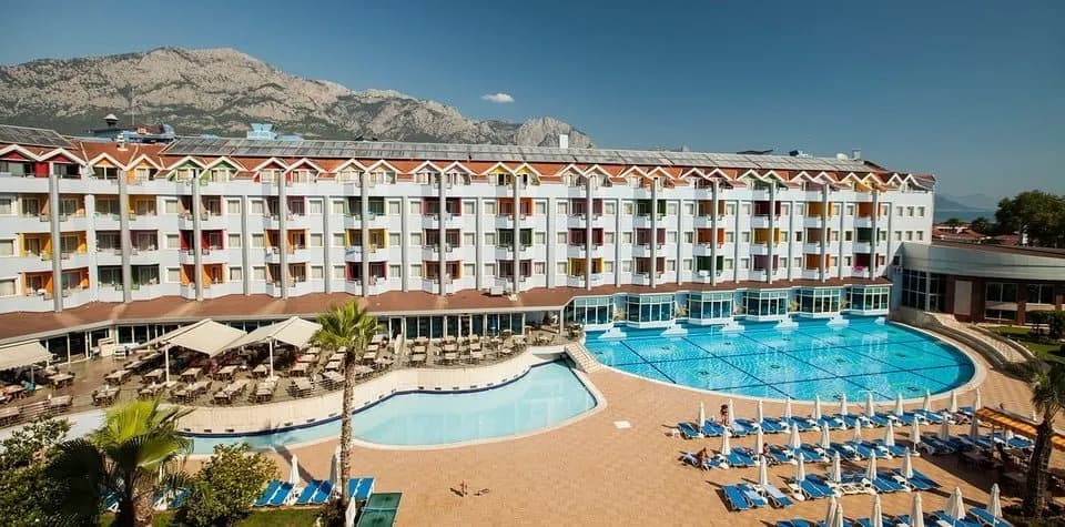 Grand Haber Hotel'in havuzu ve ana binası; arkada Toros yamaçları
