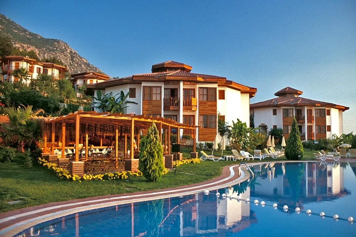 Montana Pine Resort'un havuz çevresindeki ahşap balkonlu binaları
