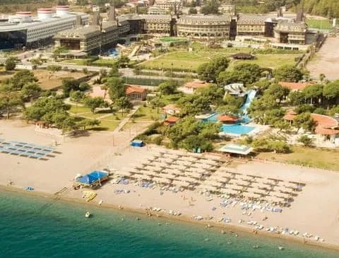 Sahil tesisinin plajı, şezlong düzeni ve yeşil bahçesi, havadan