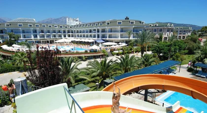 Zena Resort'un kaydıraklı havuzu; arkada dağ silsilesi