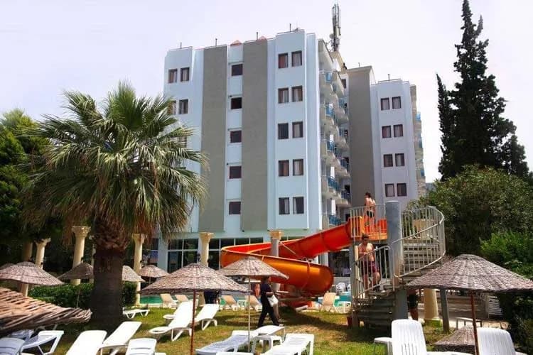 Nuova Beach Hotel'in bloğu ve bahçedeki sarı kaydırak
