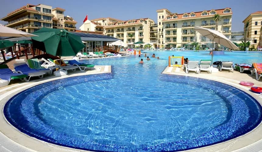 Hancı Palace Hotel'in kalabalık açık havuzu ve balkonlu blokları