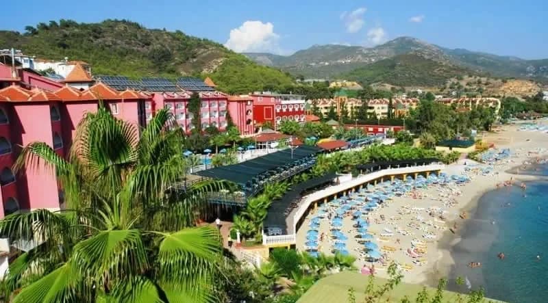 Alanya sahilinde şemsiyeli plaj ve yamaçtaki oteller