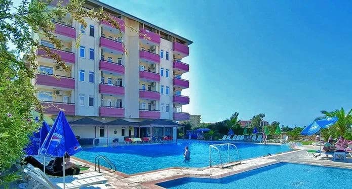 Apart otel bahçesinde açık yüzme havuzu ve şezlonglar