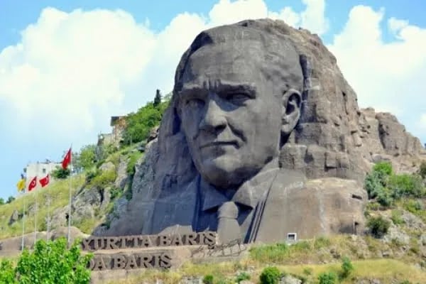 Buca'daki dev Atatürk Maskı kabartması; altında Yurtta Barış yazısı