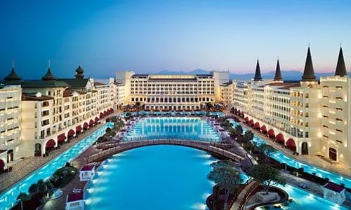 Akşam saatlerinde büyük bir resort otelin havuzlu iç avlusu