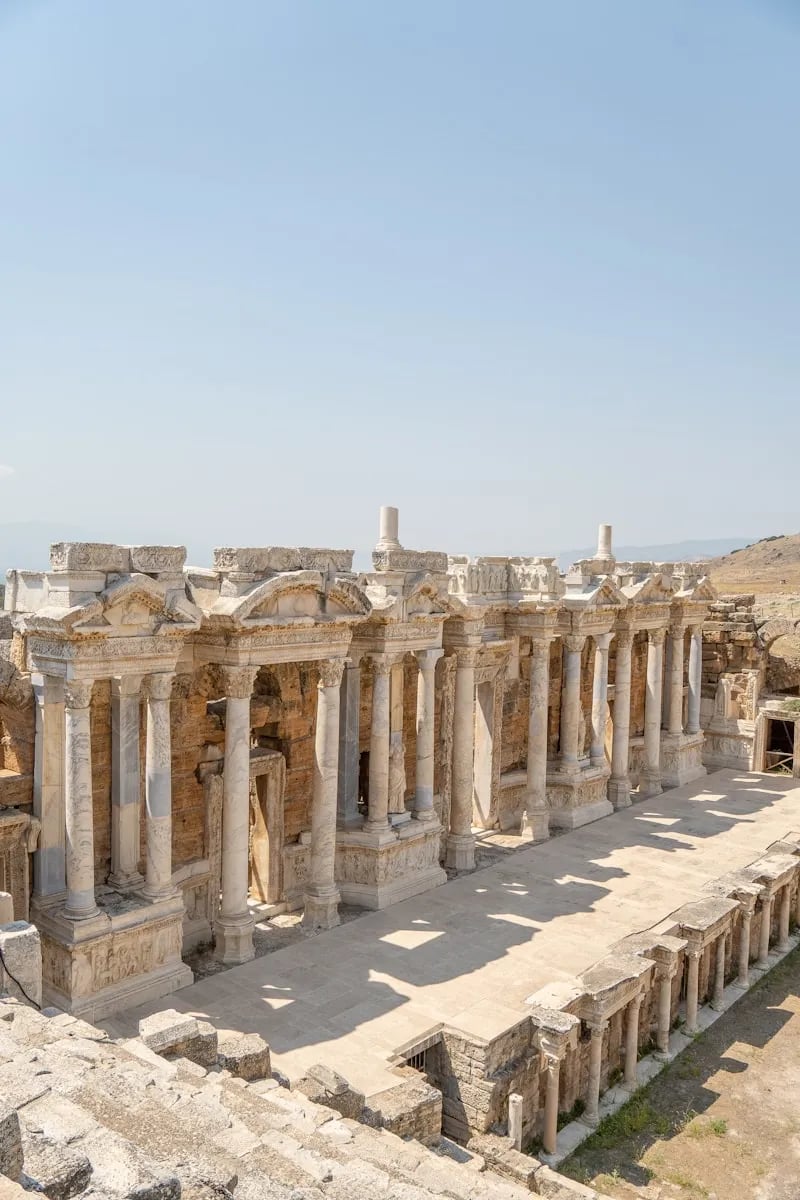Hierapolis Antik Tiyatrosu’nun sahne binası dikey görünümde; sıra sıra sütunlar, alınlıklar ve taş kabartmalar