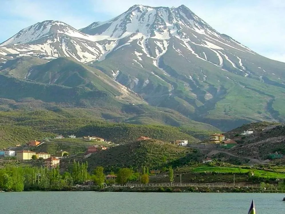 Karlı Hasandağı'nın çift zirvesi; önde baraj gölü ve kavaklar