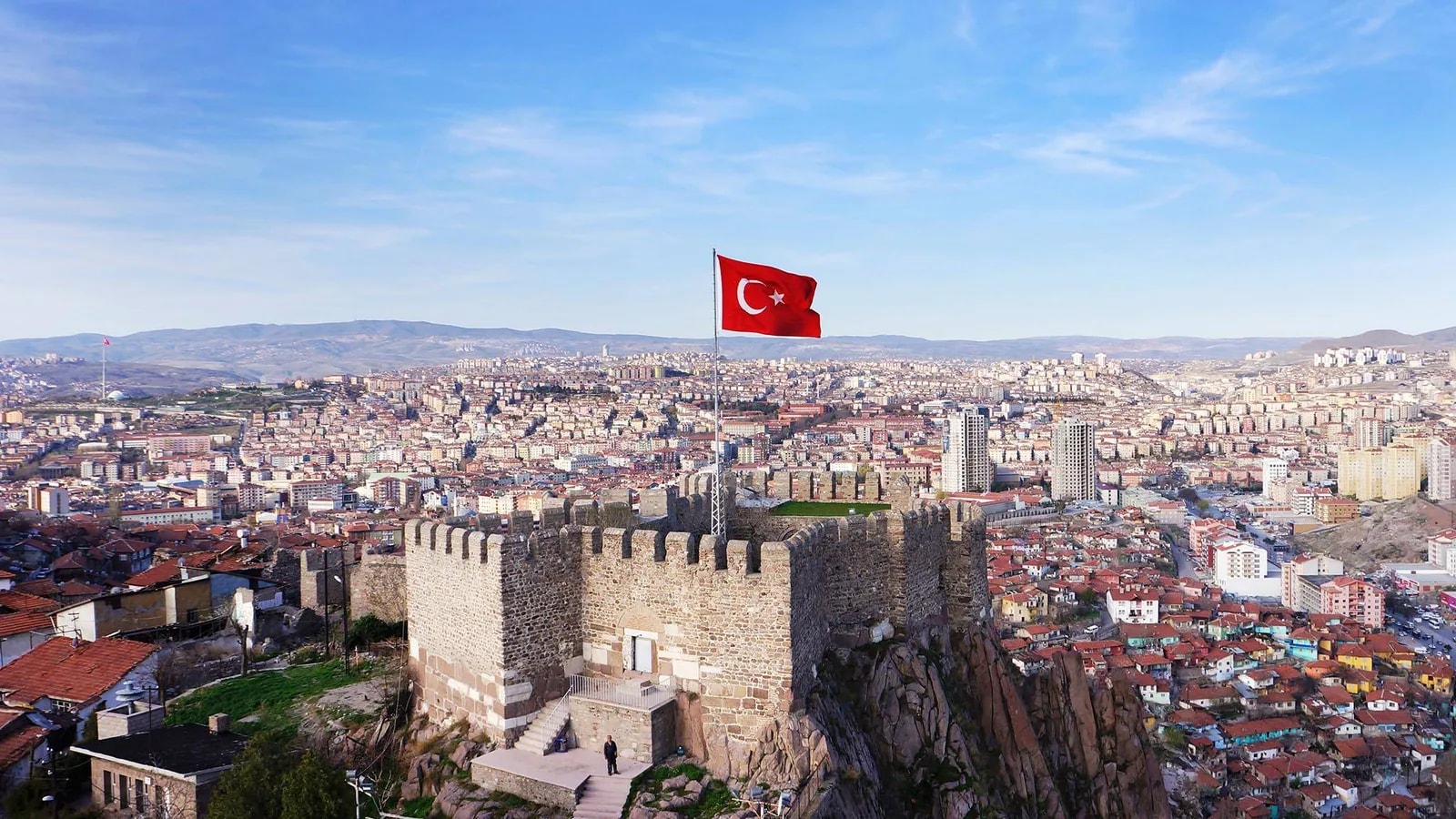 Ankara Kalesi surlarında Türk bayrağı; arkada şehir manzarası