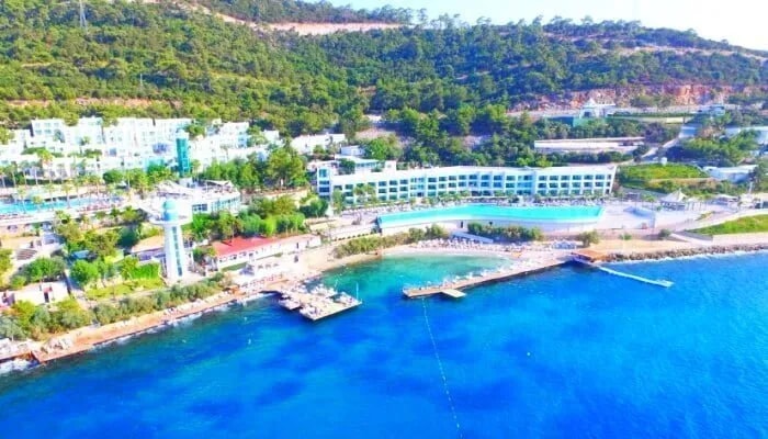 Bodrum'da koya kurulu bir tatil köyünün havuzu, iskelesi ve plajı, havadan