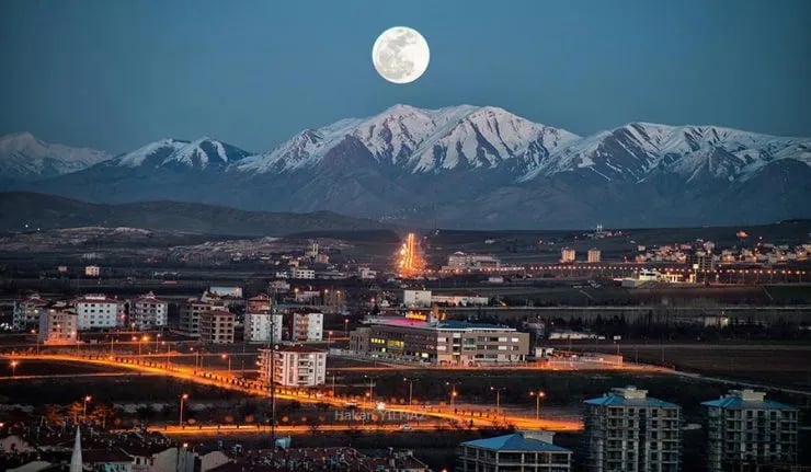 Dolunay altında gece Elazığ; arkada karlı dağ silsilesi