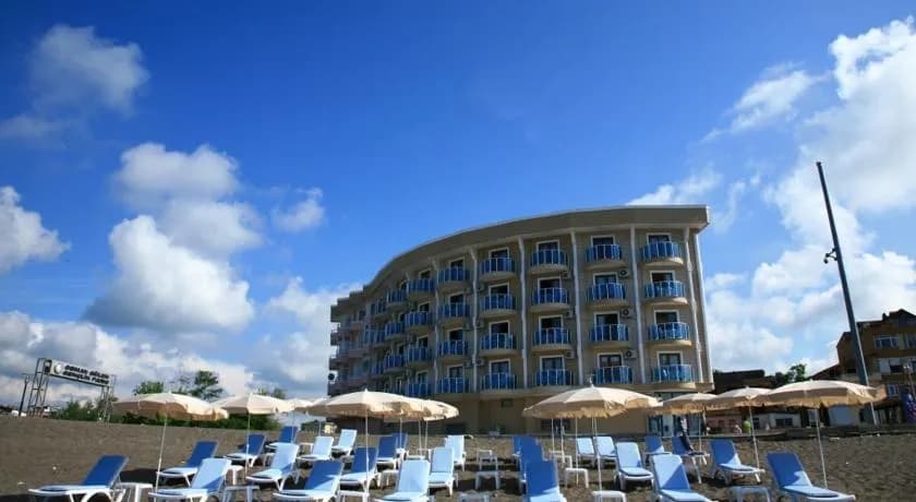 Turkuaz Beach Hotel'in kavisli bloğu ve şezlonglu terası