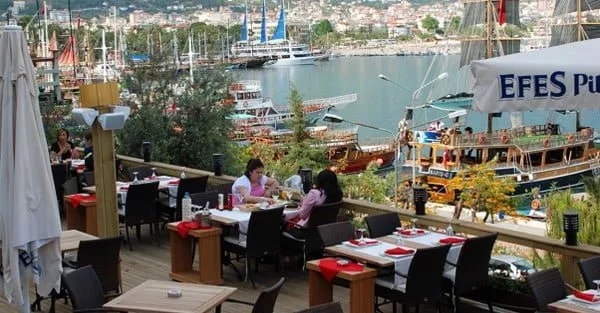 Alanya limanına bakan teras restoranda kahvaltı eden misafirler