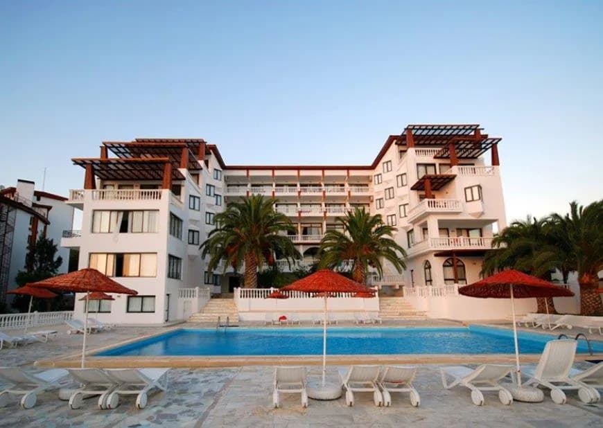 Çeşme Naz Resort'un havuzu ve palmiyeli kiremit çatılı binası