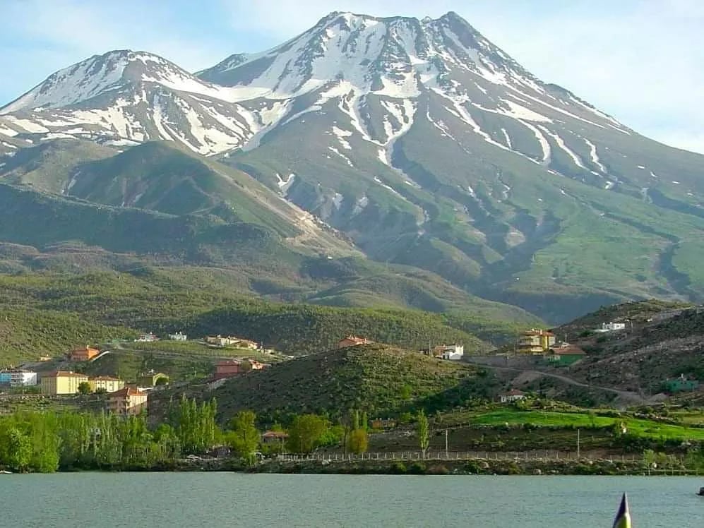 Karlı Hasandağı'nın çift zirvesi; önde baraj gölü ve kavaklar