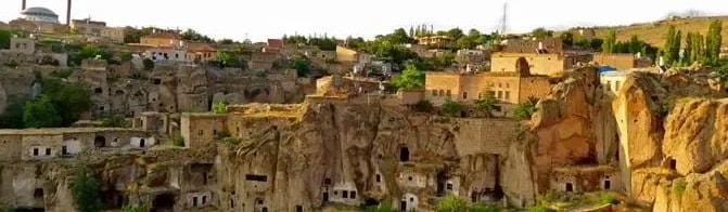 Güzelyurt’ta yamaca oyulmuş kaya evler ve vadiye bakan eski yerleşim